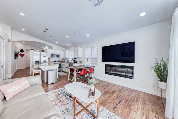A modern living room with a sofa, a coffee table, and a TV mounted on the wall. - Unique 2-Bedroom Las Vegas Home in Beautiful Summerlin- 15 Minutes to Strip (Las Vegas)