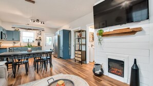 A modern kitchen with a large island, built-in appliances, and a fireplace.