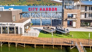 A waterfront property with a dock, a boat, and a building with a sign reading "CITY HARBOR".