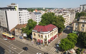 A multi-story building with a red roof, surrounded by trees and other buildings. - Villa 1927 (Belgrade)