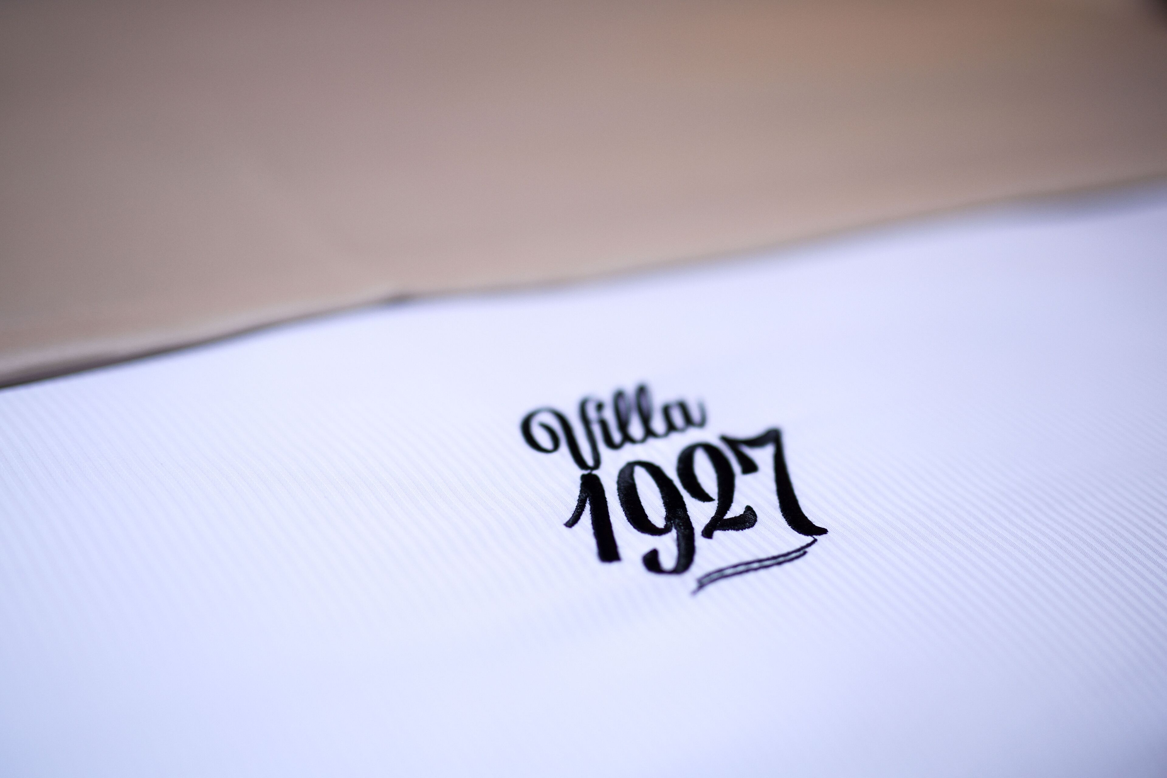 A close-up of a white surface with the text "Villa 1927" in a stylized font.