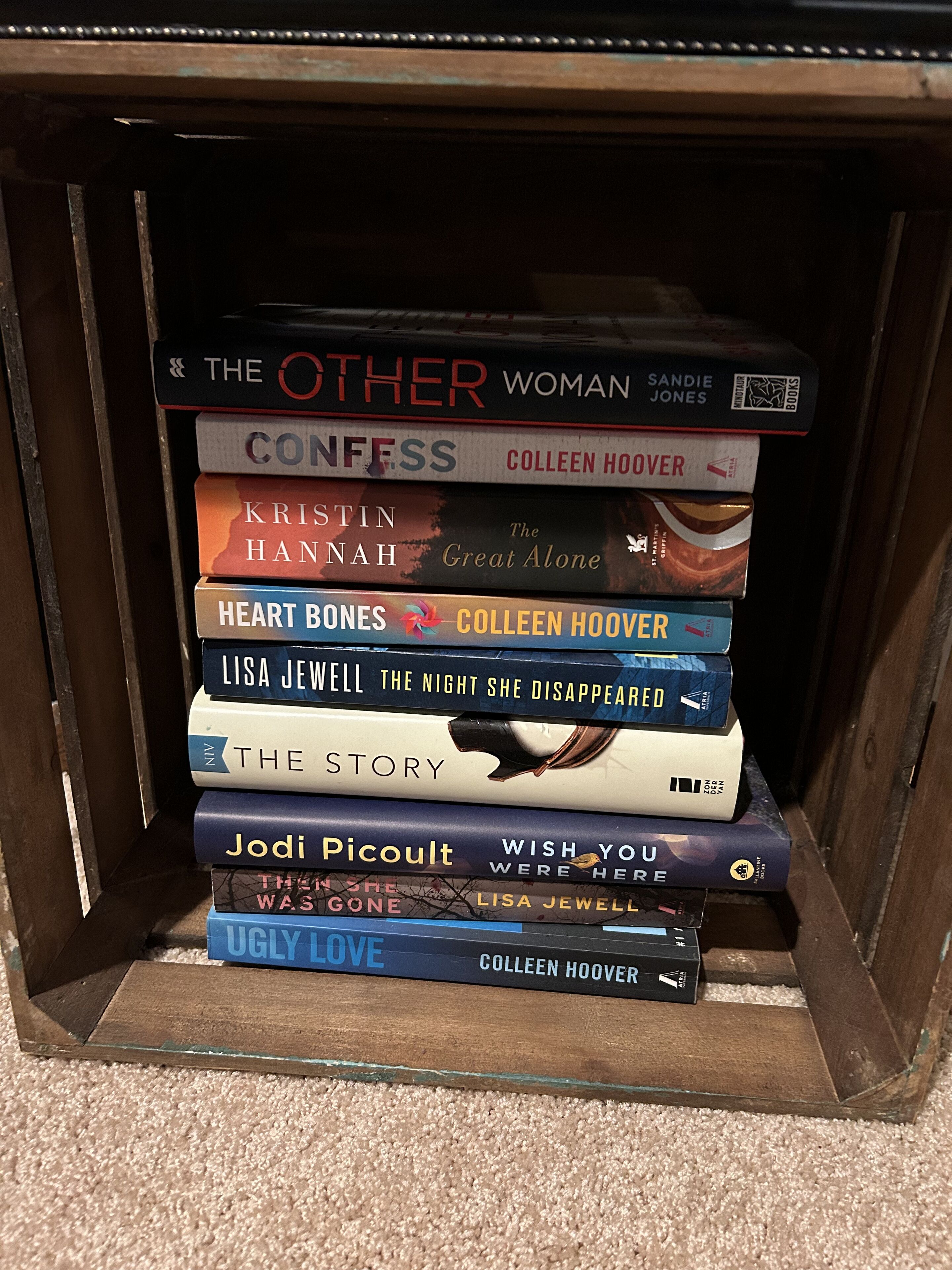 A stack of books in a wooden bookcase.