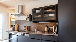 Een moderne keuken met donkere kastjes, een roestvrijstalen fornuis en een inbouw vaatwasser.