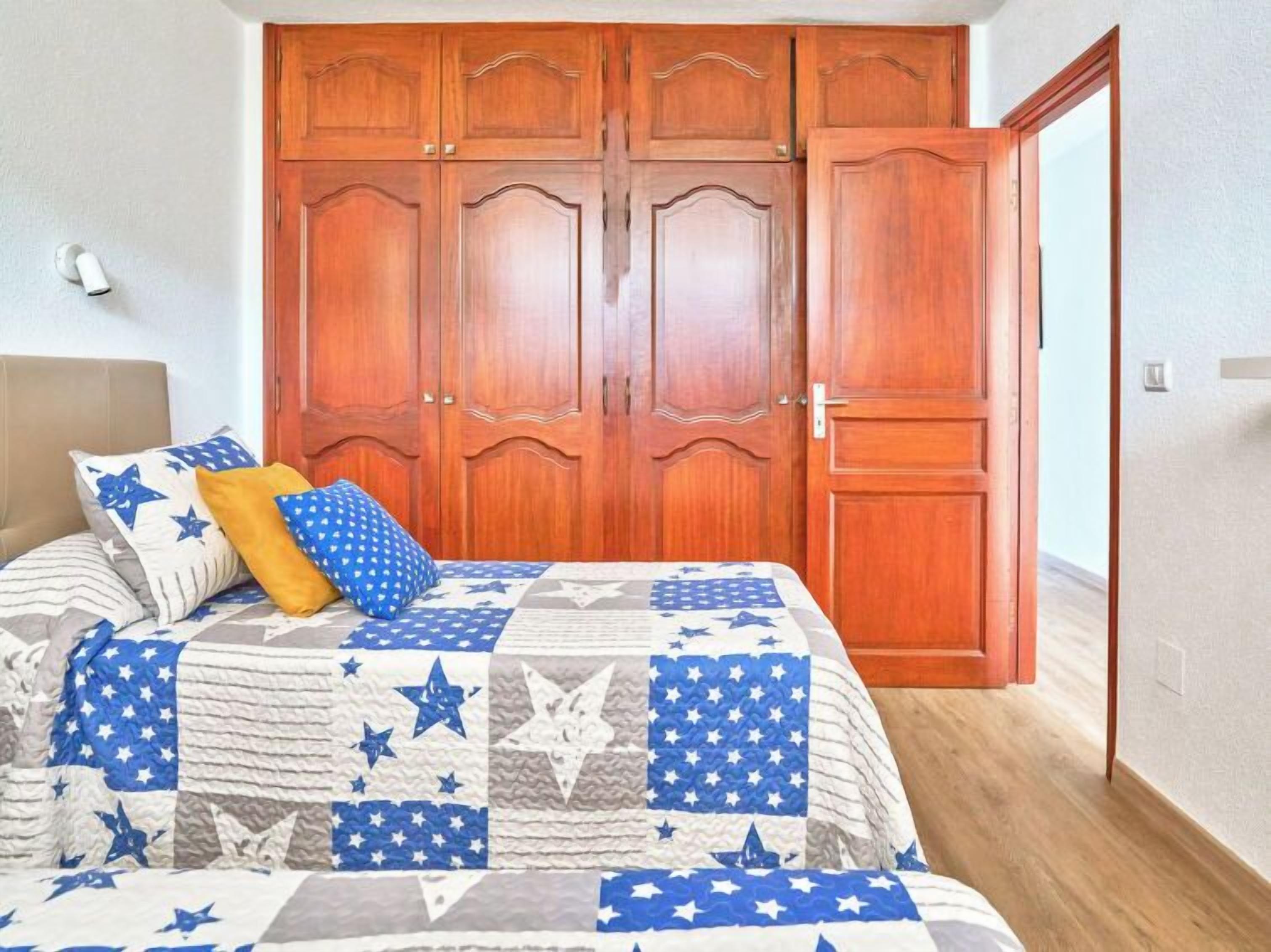 Ein Schlafzimmer mit einem Bett, einem Holzschrank und einer Tür.