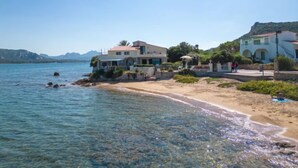 A coastal property with a beach view, a pool, and a mountain backdrop. - Donatella by Interhome (Cannigione)