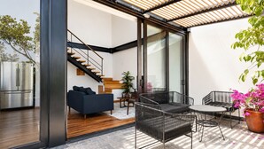 A modern interior with a staircase, a sofa, a dining area, and a large window. - Cathedral Fantastic View Loft (Heroica Puebla de Zaragoza)