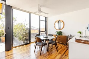 A modern dining area with a round table, chairs, and a ceiling fan. - Cathedral Fantastic View Loft (Heroica Puebla de Zaragoza)
