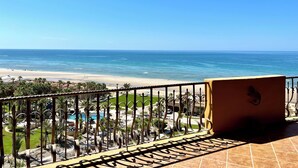 Uma varanda com vista para a praia e o oceano.