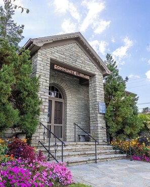 Step into the charming Community Library, surrounded by lush gardens and vibrant flowers.