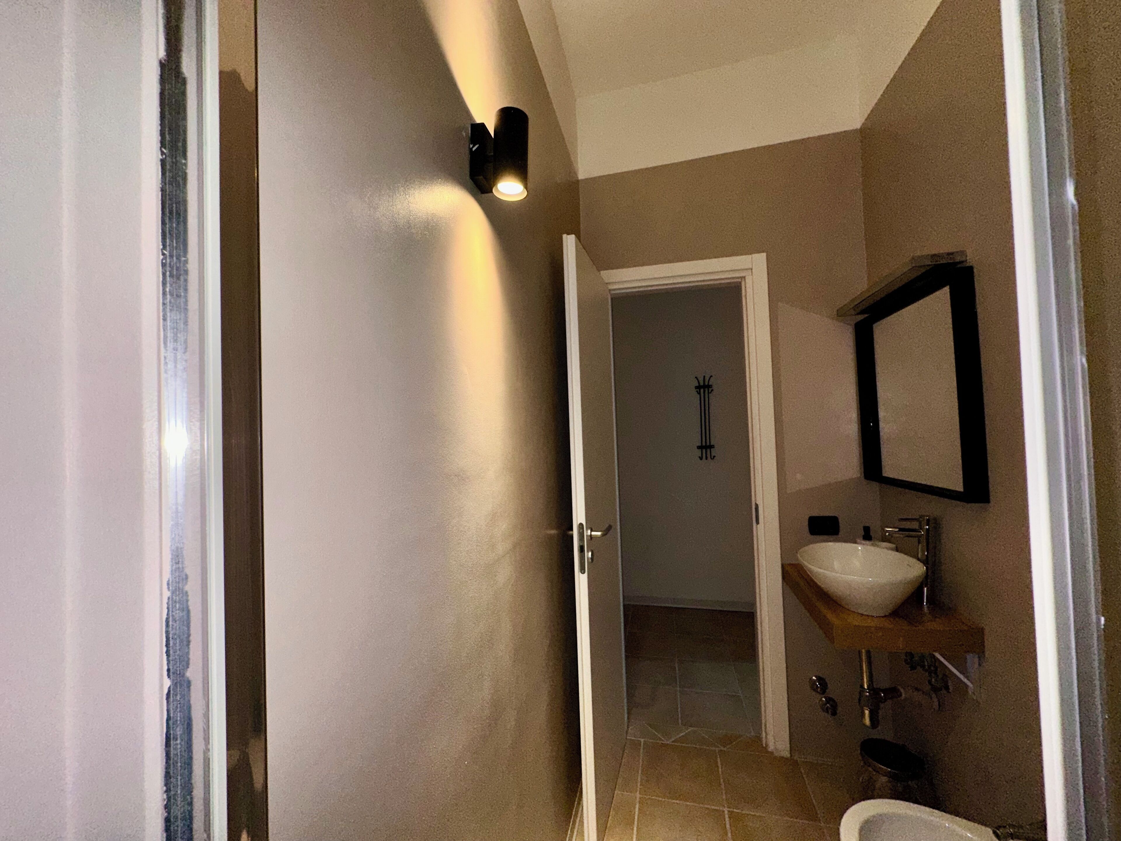 Une salle de bain avec un lavabo blanc, un miroir et une douche.