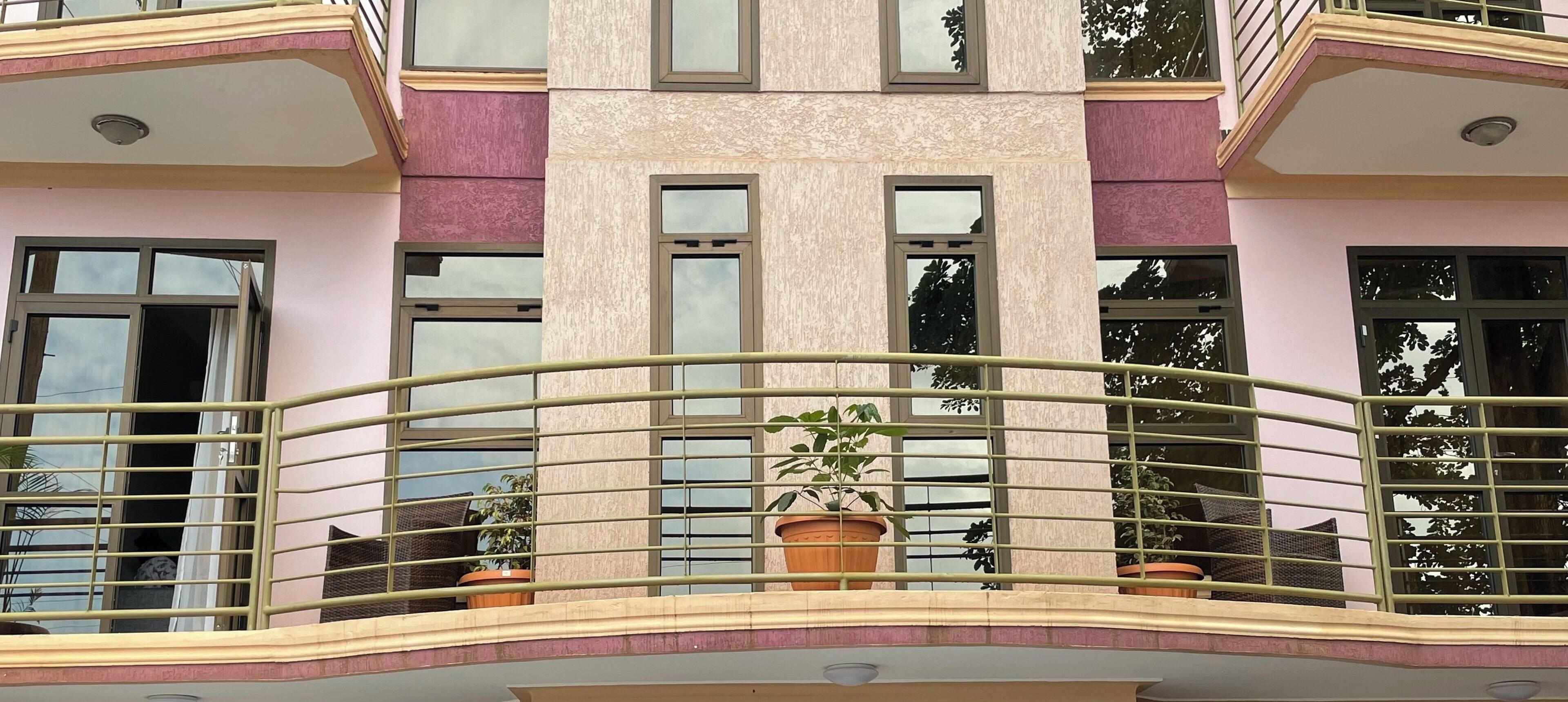 Un edificio a più piani con balconi, ampie finestre e piante in vaso.