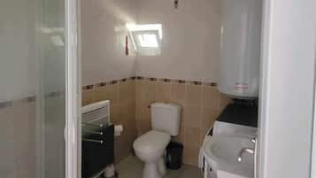 Een douche, handdoeken, zeep, toiletpapier