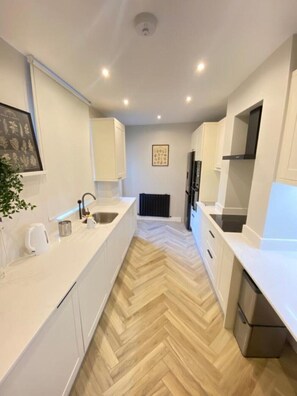 Enjoy cooking in this well-equipped kitchen with a sink, stove, and ample countertop space.
