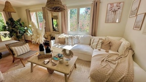 A cozy living room with a sofa, a coffee table, and a hanging light fixture. - Villa Julien (Gassin)