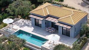 A modern house with a swimming pool, outdoor seating, and a tiled roof. - Uranos - Two Bedroom Villa, Sleeps 4 (Corfu)