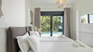 Een hotelkamer met een bed, uitzicht op een zwembad en een plafondlamp.