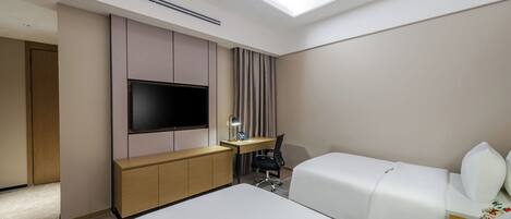 A hotel room with a bed, a desk, a chair, a TV, and a window.