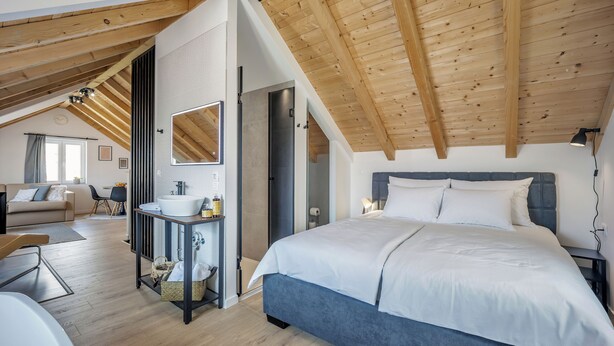A bedroom with a large bed, a bedside table, a mirror, and a bathroom with a sink and toilet. - Studio apartments Yucca 2min to the sea (Trogir)