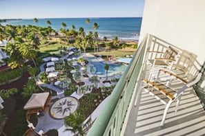 Ein Resort mit Pool, Liegestühlen und Blick auf den Ozean.
