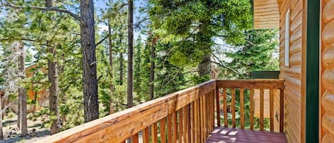 A wooden deck with a view of a forest.