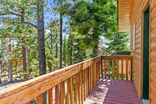 Una terraza de madera con vistas a un bosque.