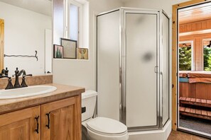 A bathroom with a shower, toilet, and sink.