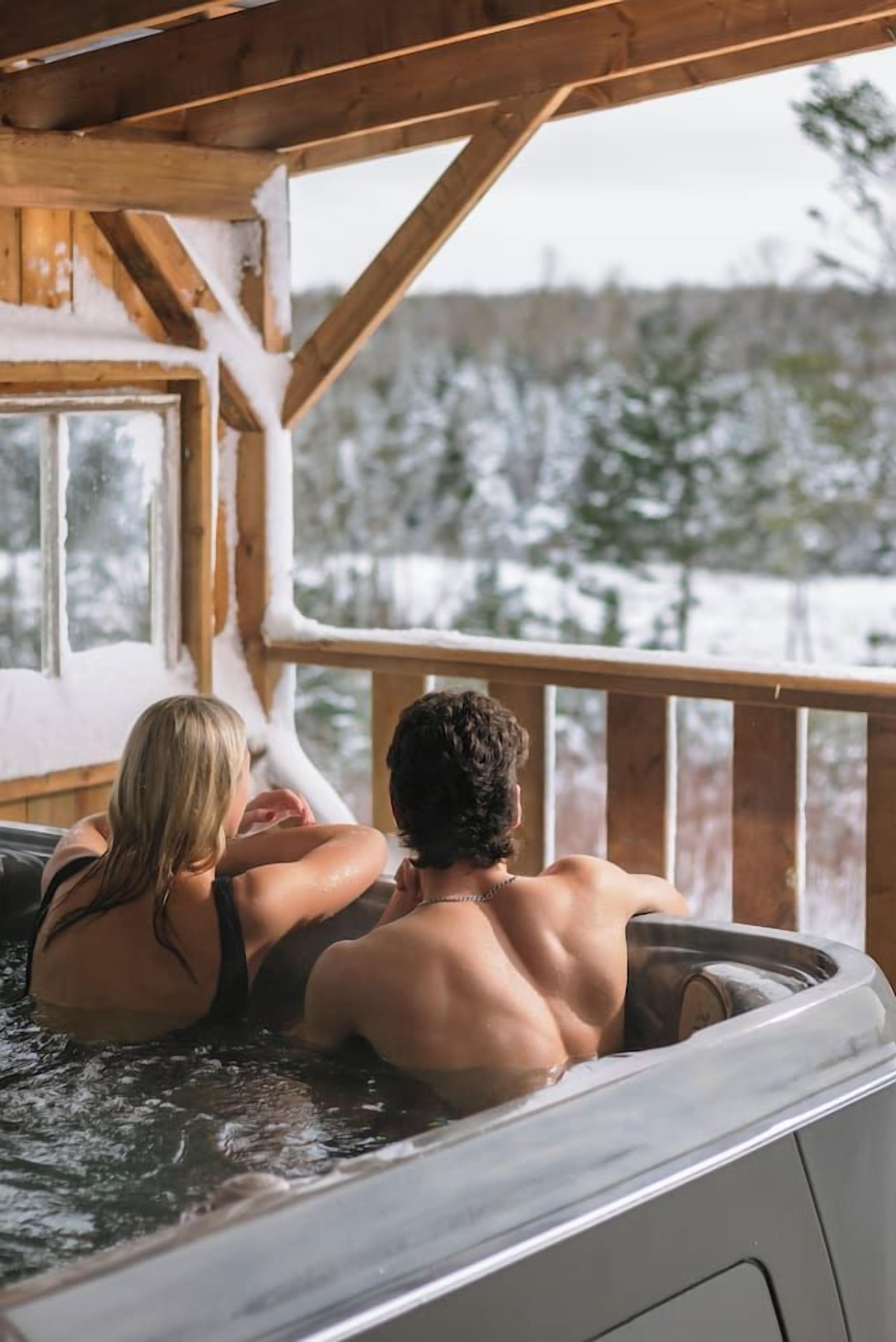 Une cabane en bois avec un bain à remous.