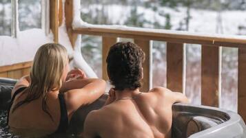 Une cabane en bois avec un bain à remous.