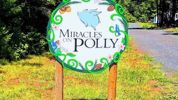 Ein Schild mit dem Schriftzug 'Miracles on Polly', umgeben von dekorativen Elementen.