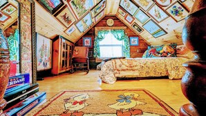 A cozy attic room with a sloped ceiling, wooden walls, and a large window. - Miracles on Polly - Memory Lane Cabin (Belfast)