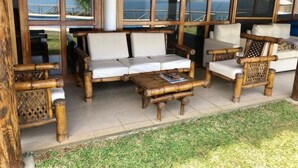Un espacio de descanso al aire libre con madera, que incluye un sofá, sillas y una mesa.