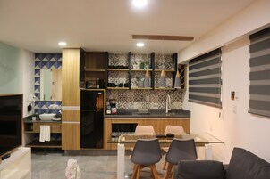Una cocina moderna con una mesa de comedor de vidrio, armarios de madera y un horno empotrado.
