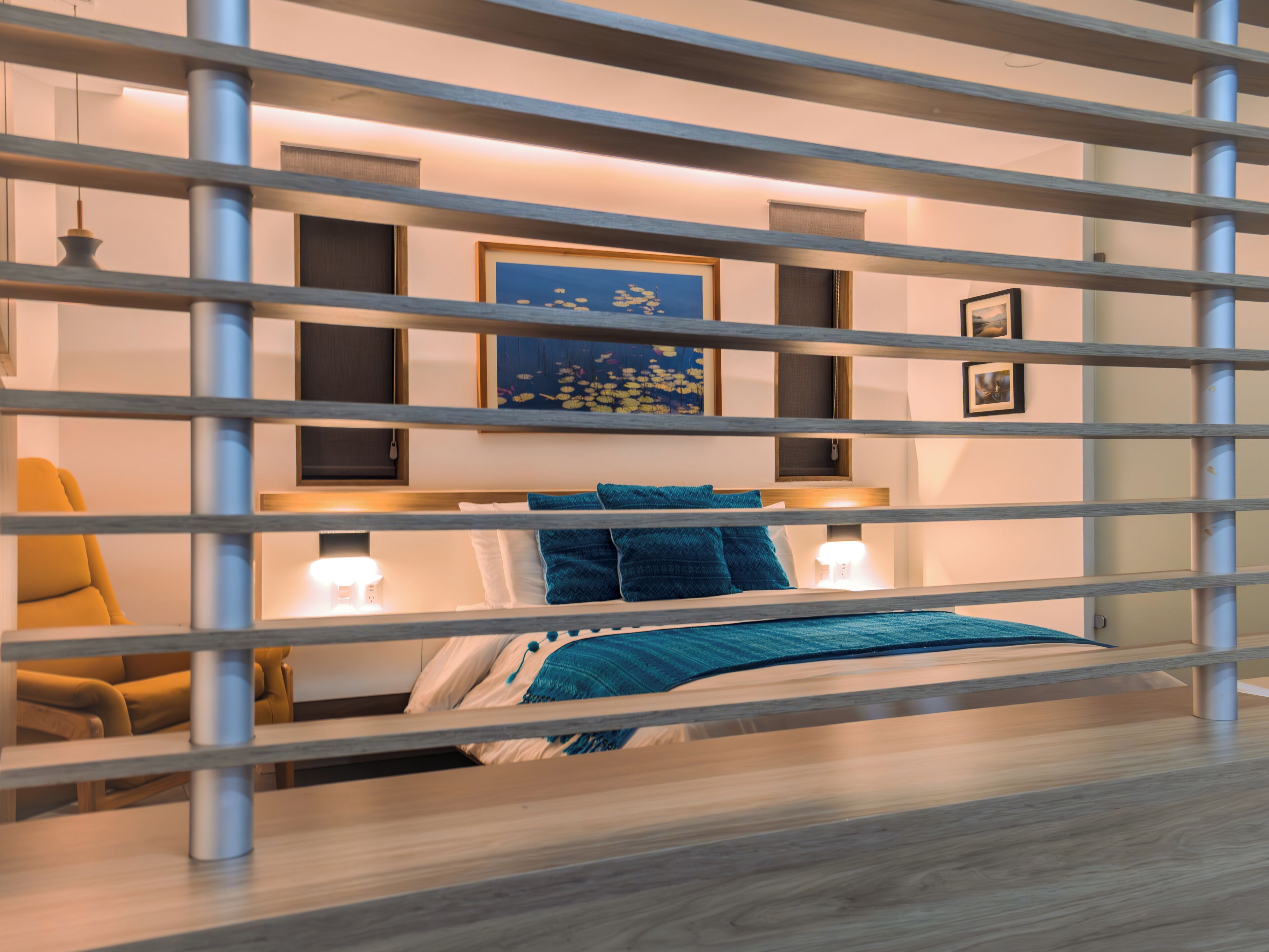 A modern bedroom with a bed, bedside tables, and a chair.