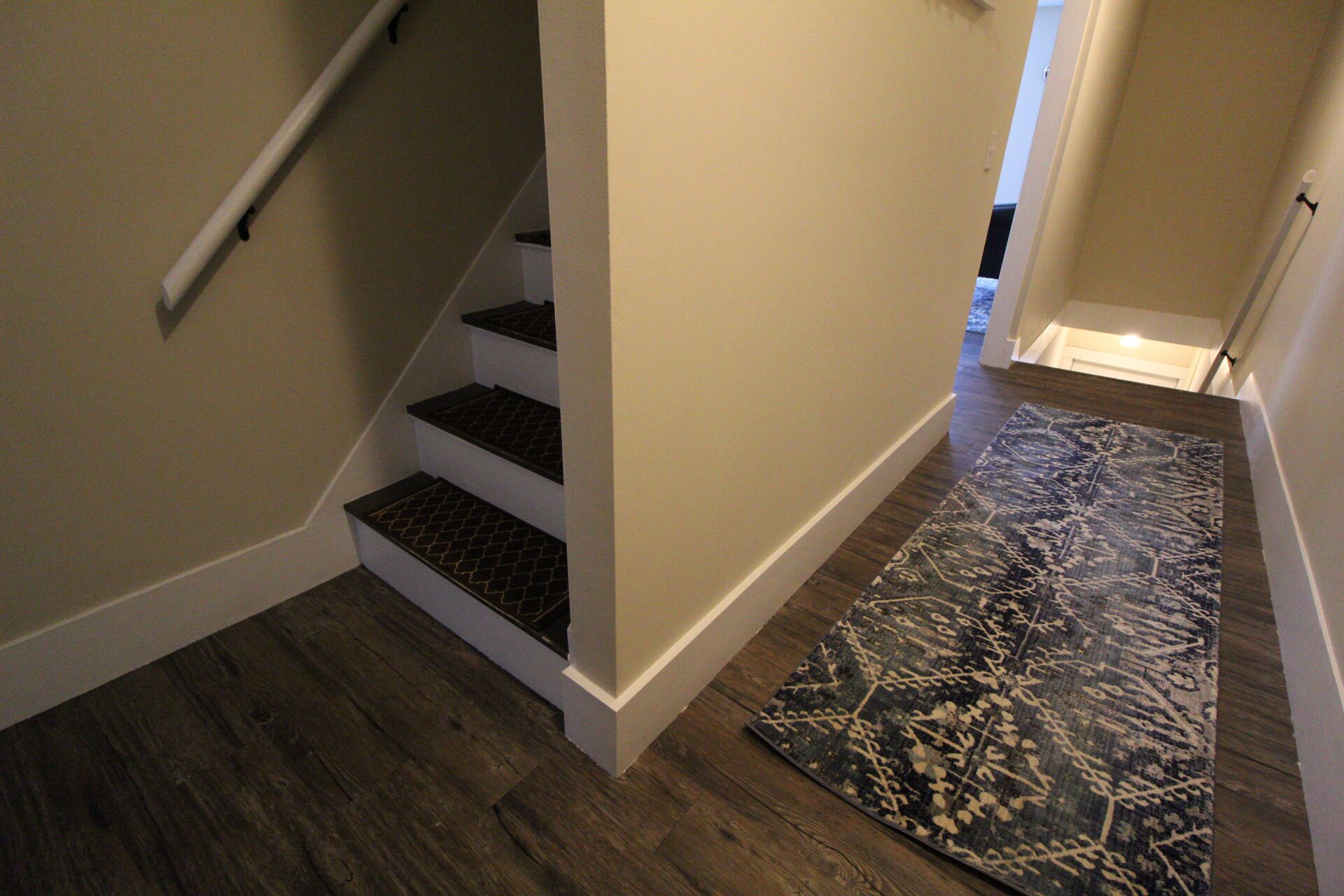 Una escalera con escalones de madera y un tapete estampado al final.