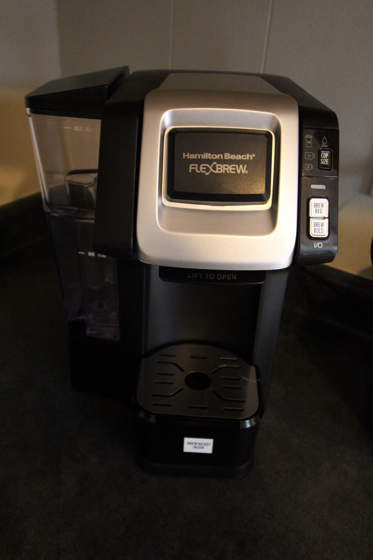 Une machine à café Hamilton Beach Flexbrew dotée d’un réservoir d’eau transparent, d’un bac de récupération et d’un porte-filtre.