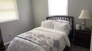 Cozy retreat with a neatly made bed, nightstand, and lamp.