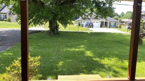 Enjoy a peaceful living environment surrounded by a well-maintained lawn and a large tree.