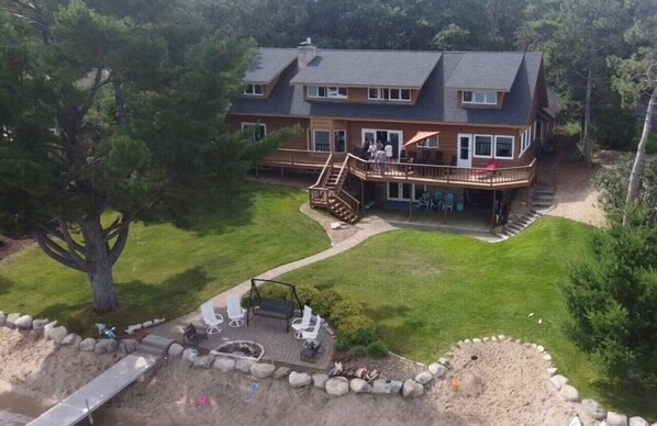 A large two-story house with a deck, a fire pit, and outdoor seating. - Beautiful lake home on the sandy south shores of Pelican Lake. (Nisswa)