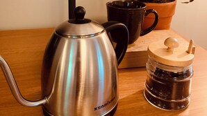 A coffee maker with a funnel, a mug, and a jar with a lid on a wooden table. - Loblolly Pines Adventure Camp Unit 3 (Eureka Springs)