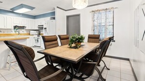 A modern kitchen with white cabinets, a central island, and a chandelier. - Enjoy Southern Hospitality in Kingland Georgia, Bring Pets, Plenty Parking (Kingsland)