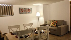 A living room with a dining table, chairs, a sofa, and a lamp. - Plátanos & River Views I (Ponte de Lima)