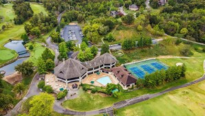 A golf course with a clubhouse, swimming pool, and tennis courts.