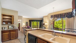 A kitchen with a large island, wooden cabinets, and a dishwasher.