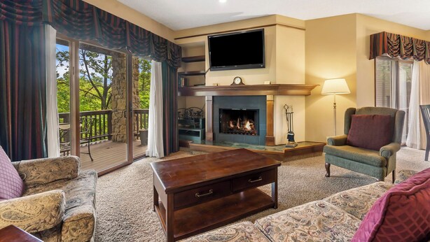 A living room with a fireplace, a flat-screen TV, and a comfortable seating area.