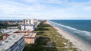 A coastal hotel with multiple buildings, a beach, and the ocean. - Cozy Ground Floor Walkout w/Ocean View (Cocoa Beach)