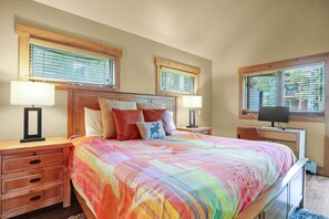 A bedroom with a large bed, two bedside tables with lamps, a desk with a computer, and windows with blinds. - Private Hot Tub - Huge Covered Deck- Garage - On Ski Bus Route (Steamboat Springs)