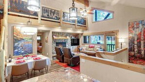A spacious living area with a fireplace, seating, and artwork.