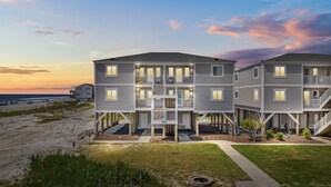 A beachfront multi-story residential building with balconies, a covered walkway, and a view of the ocean. - BEACHFRONT!!! Updated 2 Bedroom 2 Bath  Condo (Ocean Isle Beach)