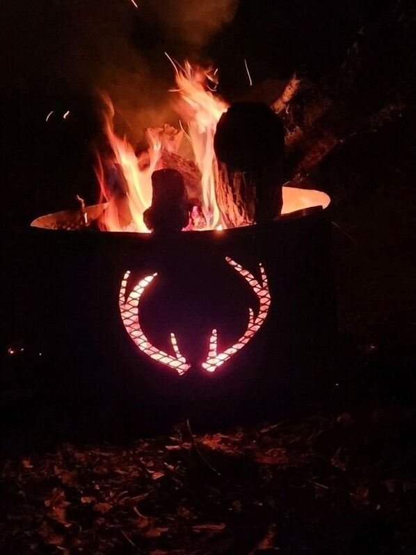 A campfire with a glowing pumpkin decoration in the center.