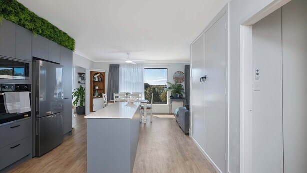 A modern kitchen with a central island, built-in appliances, and a view to the outdoors.